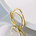 Gold sculptural ring on a light gray surface
