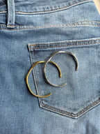Two gold bracelets on a blue denim background