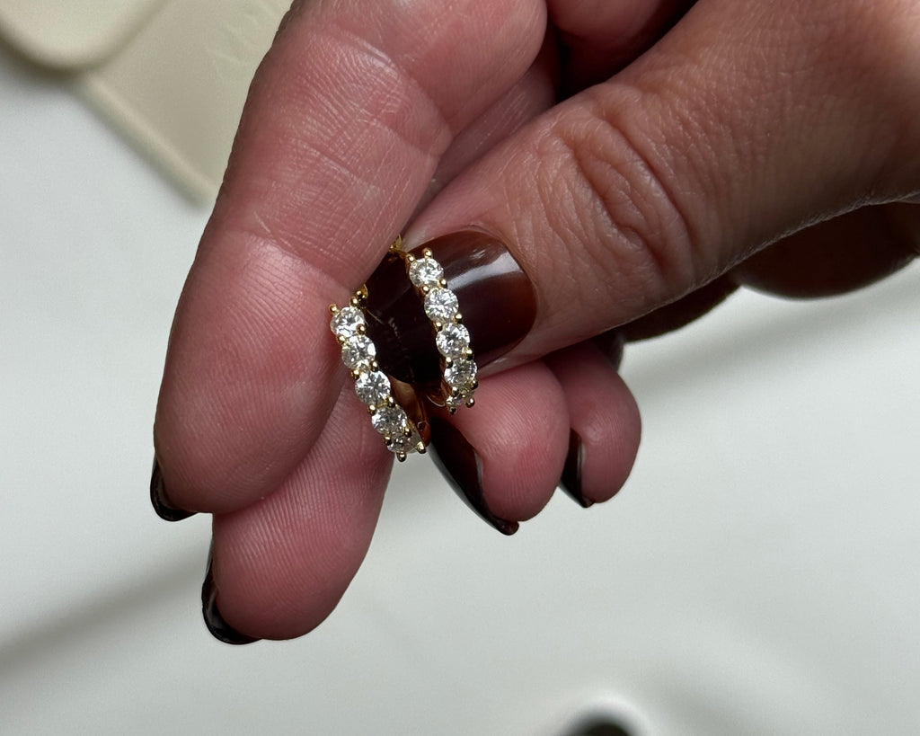 Hand holding two diamond rings with a blurred background