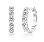 Pair of silver hoop earrings with clear gemstones on a white background