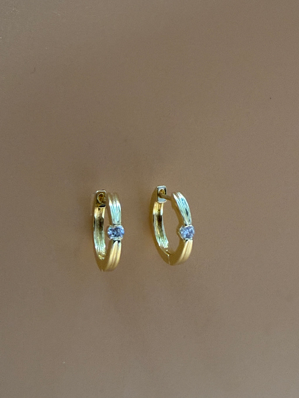 mirelle earrings on an orange background